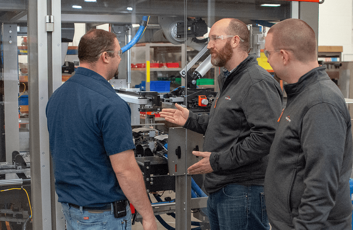 People talking around a packaging machine