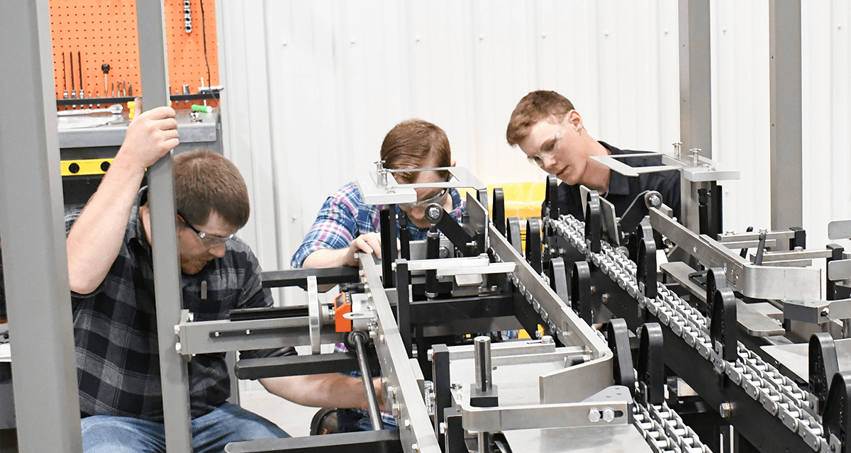Three technicians doing hands-on training on a piece of equipment