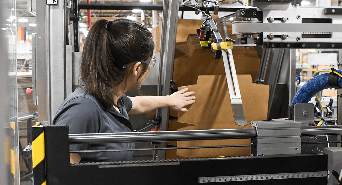 Operator reach into machine to adjust magazine infeed