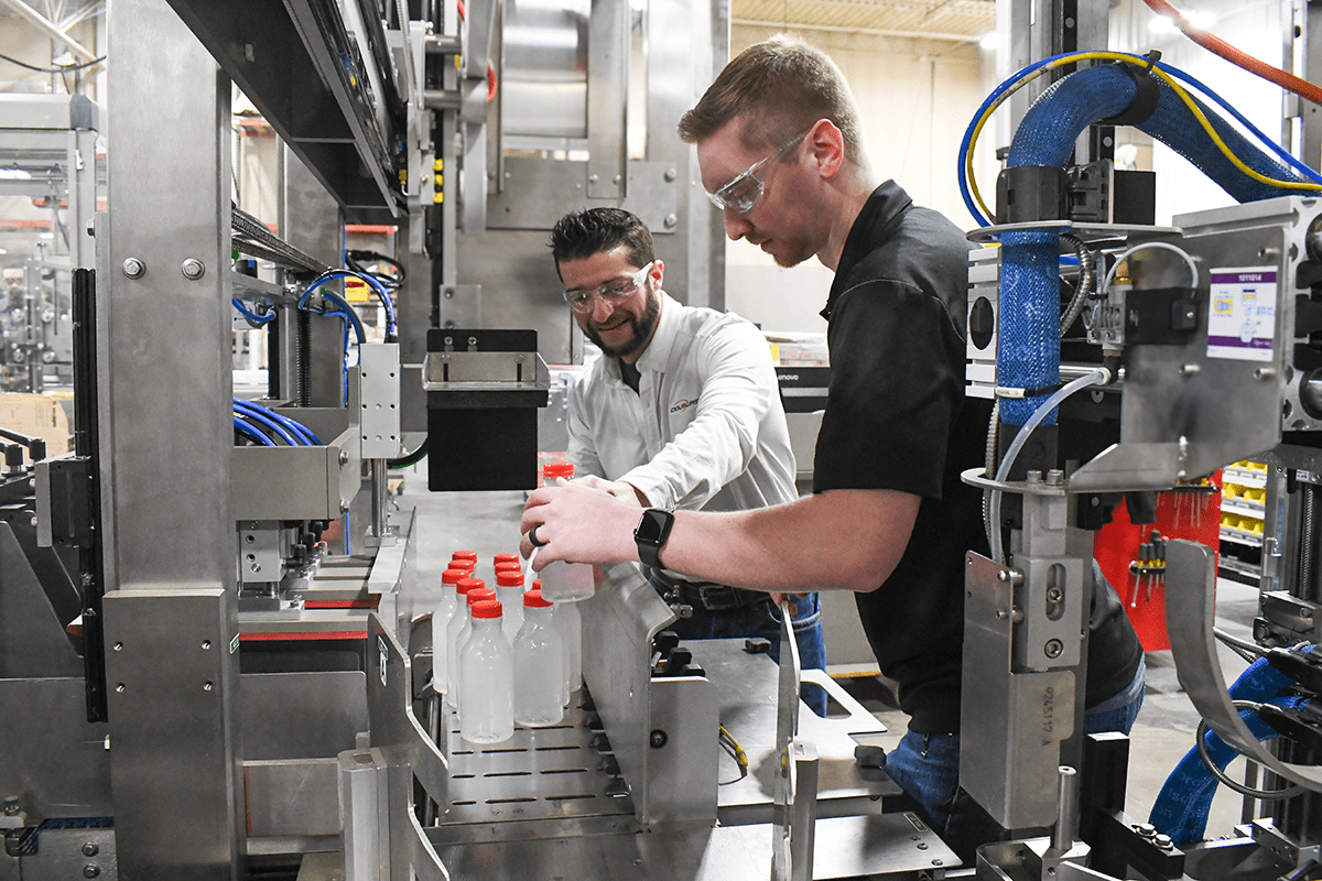 Two men working by a packaging machine