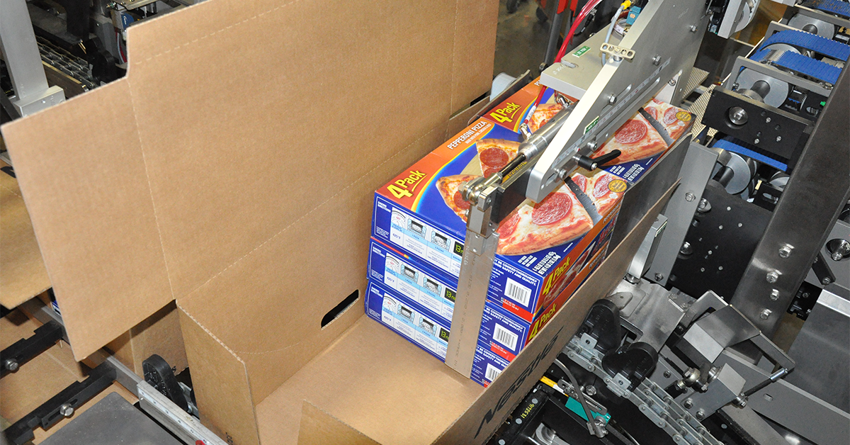 Side load case packer packing cartons of pizza into corrugate case