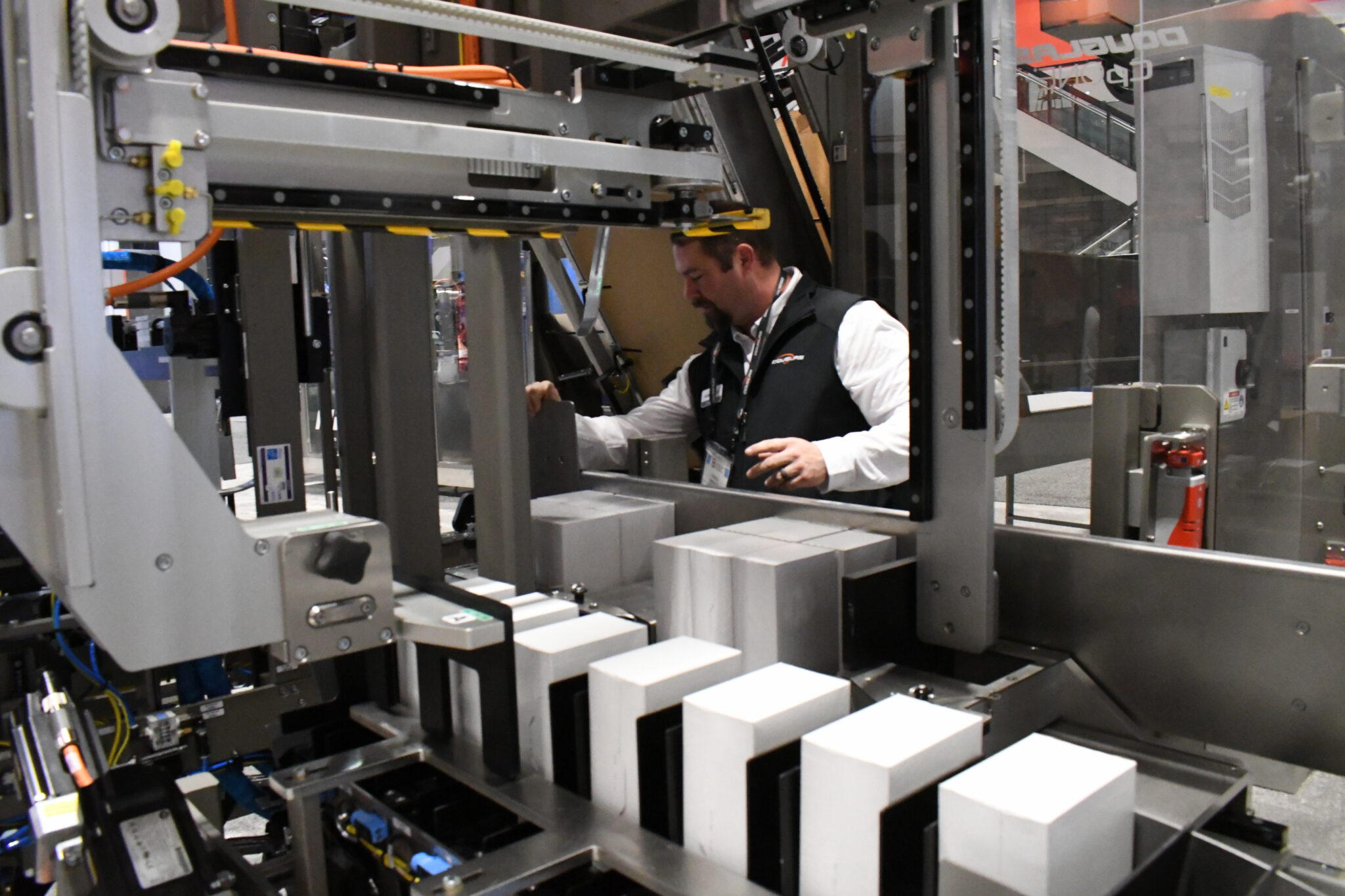 Operator standing by CpONE machine while it collates cartons