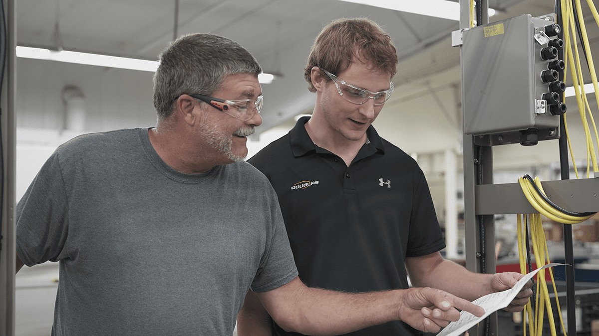 Two people at machine looking at document